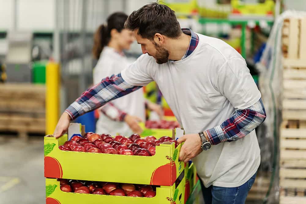 Imagen de trabajador con caja de fruta
